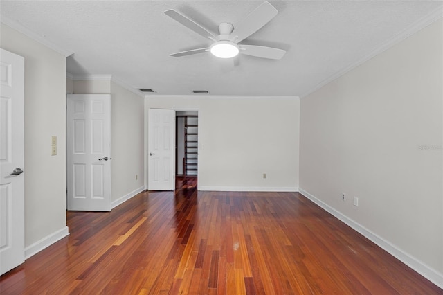 unfurnished bedroom featuring a textured ceiling, ceiling fan, ornamental molding, and dark wood-type flooring