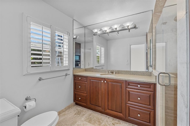 bathroom featuring vanity, toilet, and walk in shower