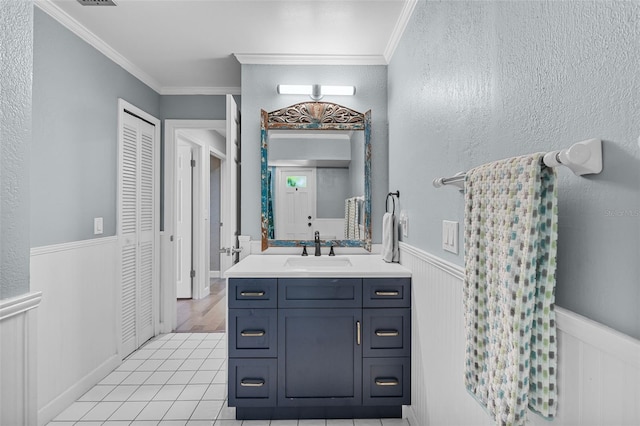 bathroom with tile patterned floors, vanity, and crown molding