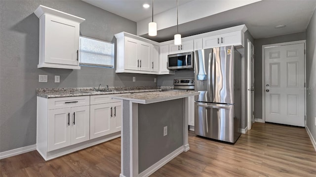 kitchen featuring sink, white cabinets, pendant lighting, and appliances with stainless steel finishes