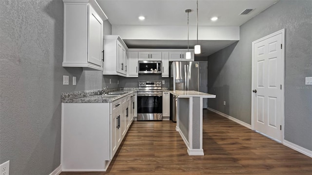 kitchen featuring hanging light fixtures, stainless steel appliances, dark hardwood / wood-style floors, light stone counters, and white cabinets