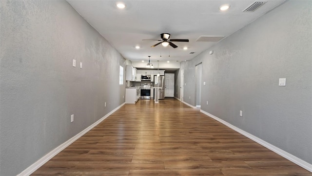 unfurnished living room with ceiling fan and dark hardwood / wood-style flooring