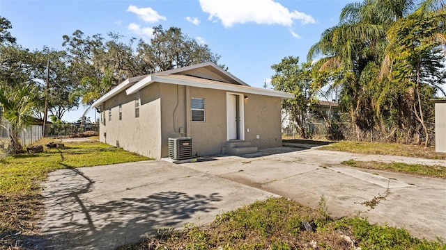 view of front of house with central AC and a patio area