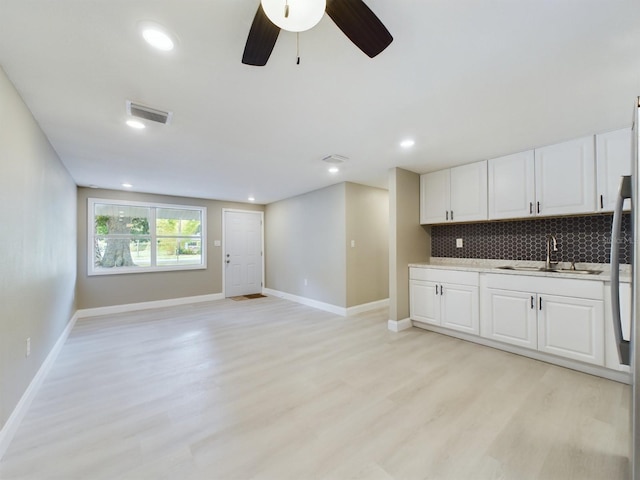 kitchen featuring white cabinets, light hardwood / wood-style flooring, and sink