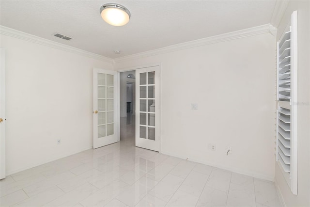 spare room with crown molding and french doors