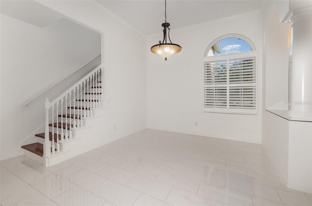 spare room with crown molding and decorative columns