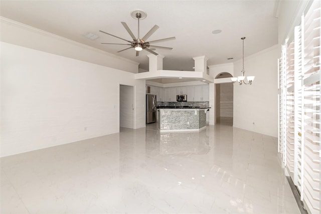 unfurnished living room with ceiling fan with notable chandelier and crown molding