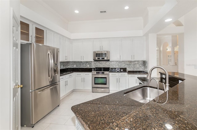 kitchen featuring dark stone counters, sink, white cabinets, and stainless steel appliances