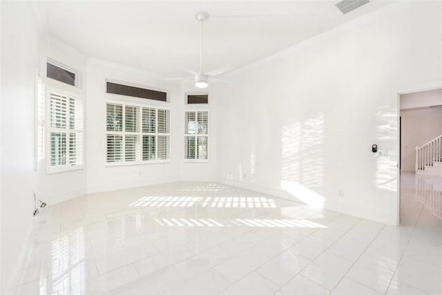 unfurnished room featuring ceiling fan, ornamental molding, and light tile patterned flooring