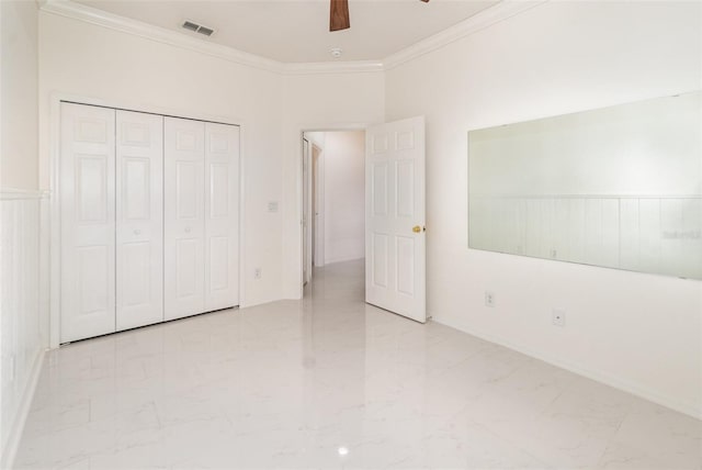 unfurnished bedroom with a closet, crown molding, and ceiling fan