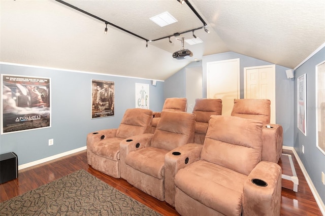 cinema featuring dark hardwood / wood-style floors, a textured ceiling, track lighting, and vaulted ceiling