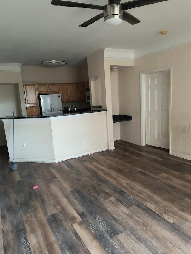 kitchen with dark hardwood / wood-style flooring, stainless steel refrigerator, ceiling fan, and sink