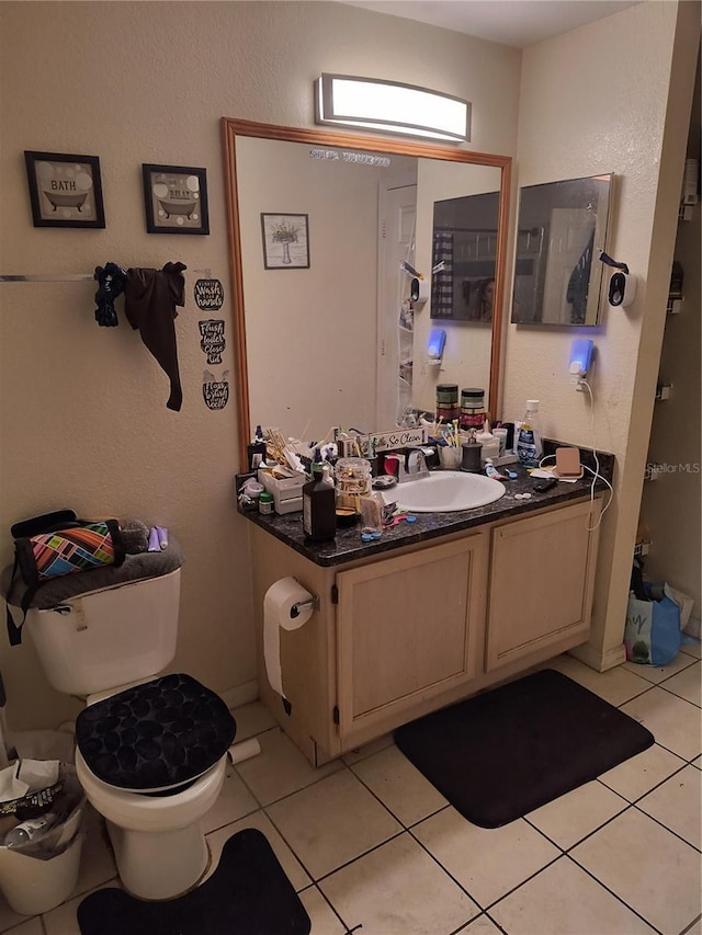 bathroom featuring tile patterned flooring, vanity, and toilet