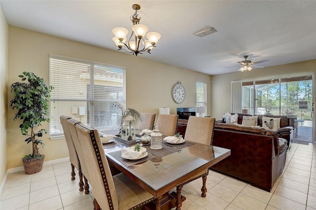 dining space with ceiling fan with notable chandelier, light tile patterned floors, and a textured ceiling