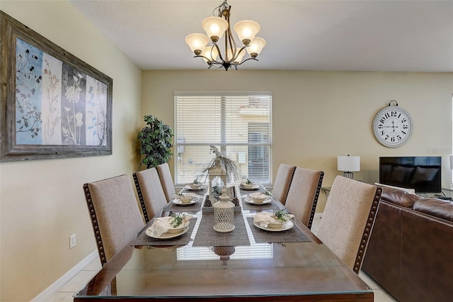 tiled dining space with a textured ceiling and a chandelier