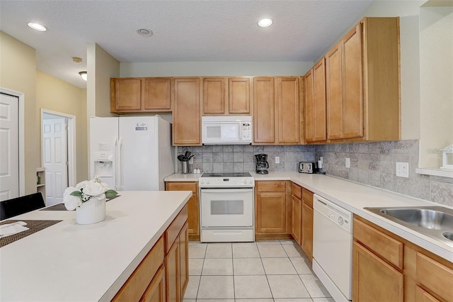 kitchen featuring white appliances, sink, a textured ceiling, tasteful backsplash, and light tile patterned flooring