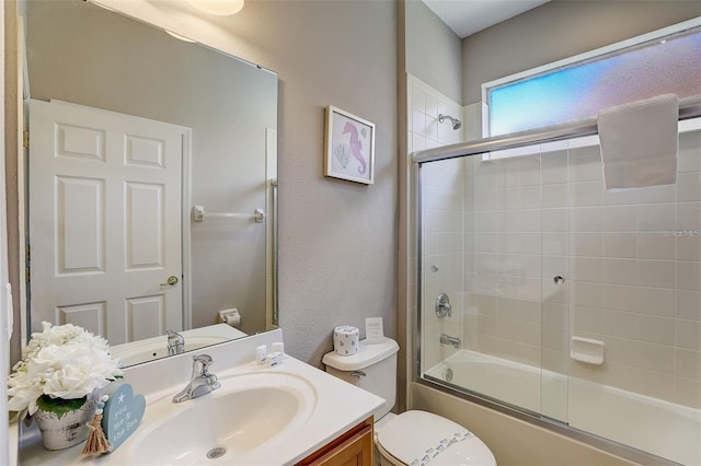 full bathroom featuring combined bath / shower with glass door, vanity, and toilet