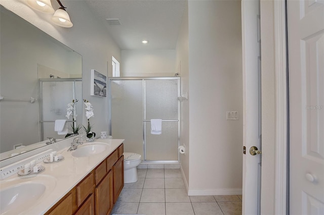 bathroom featuring tile patterned floors, a shower with door, vanity, and toilet