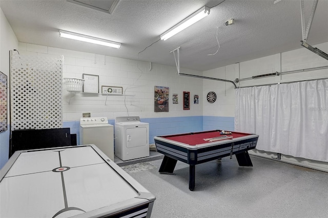 playroom with a textured ceiling, pool table, and washing machine and clothes dryer