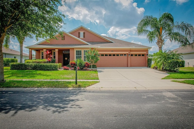 view of front of home featuring a garage, driveway, a front lawn, and stucco siding