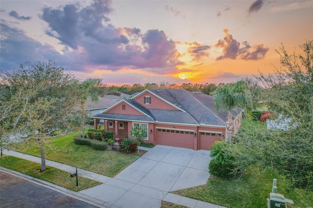 view of front of property featuring a garage, a front lawn, and concrete driveway