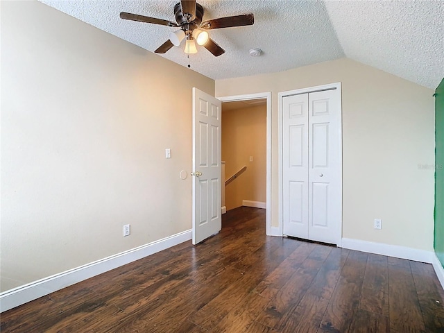 unfurnished bedroom with ceiling fan, dark wood-type flooring, a textured ceiling, and a closet