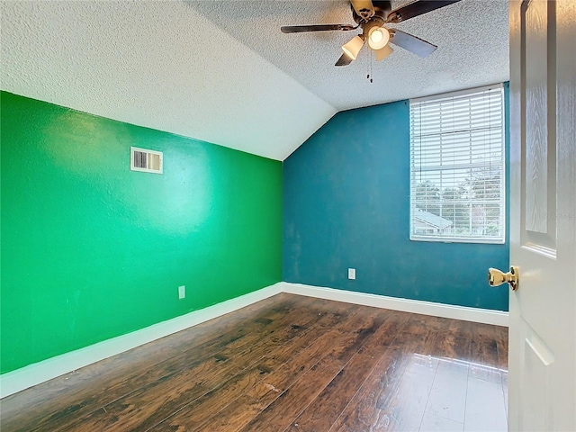 additional living space with ceiling fan, dark wood-type flooring, a textured ceiling, and vaulted ceiling