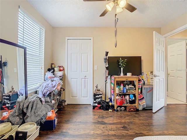 playroom featuring a textured ceiling, ceiling fan, and dark hardwood / wood-style flooring