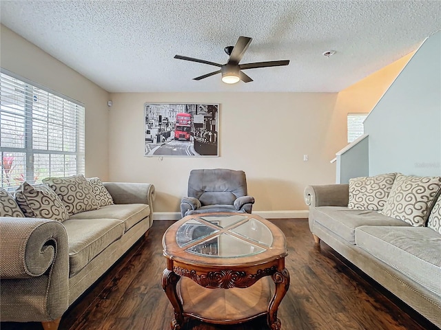 living room with a textured ceiling, ceiling fan, and dark hardwood / wood-style flooring