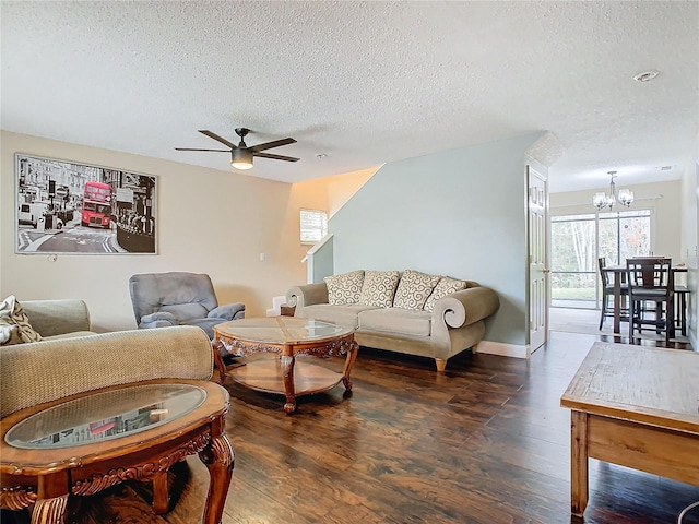 living room featuring dark hardwood / wood-style floors, ceiling fan with notable chandelier, and a textured ceiling