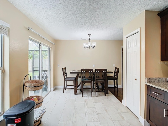 dining room featuring a textured ceiling and a chandelier