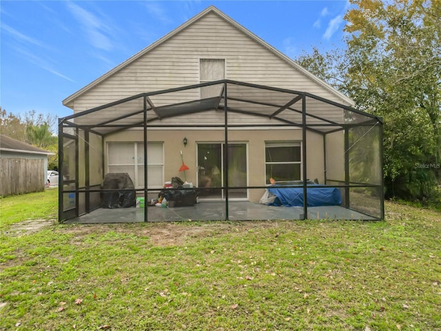 rear view of property with a lawn, a patio, and glass enclosure