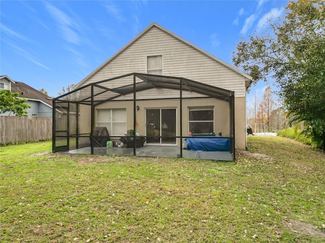 back of property with a patio area, a lanai, and a yard