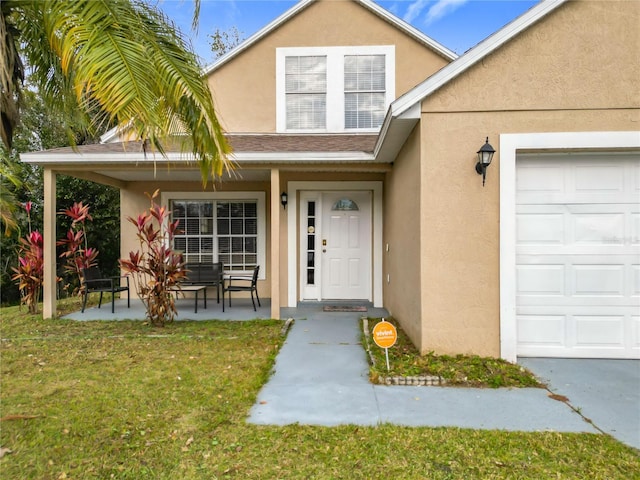 doorway to property with a yard, a porch, and a garage