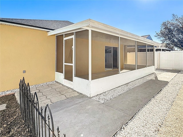 view of side of home with a patio area and a sunroom