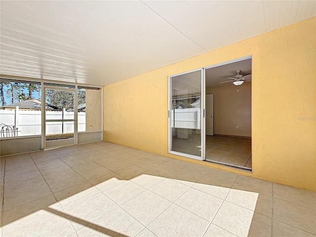 unfurnished sunroom featuring ceiling fan