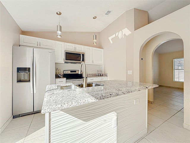 kitchen with hanging light fixtures, appliances with stainless steel finishes, white cabinetry, and a kitchen island with sink