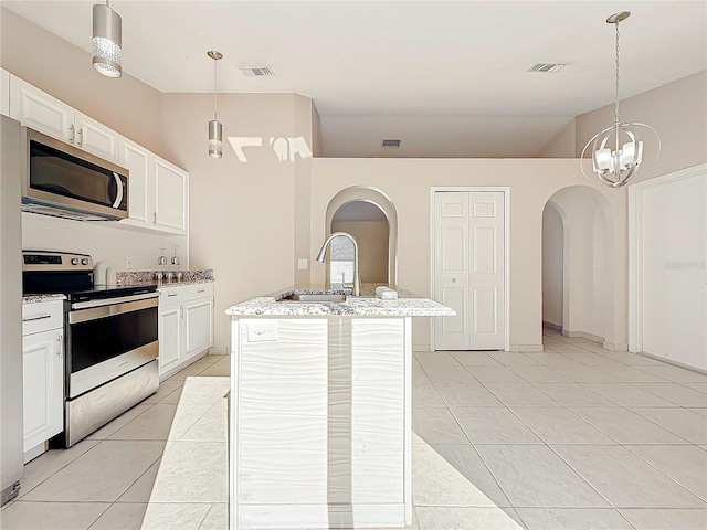 kitchen with appliances with stainless steel finishes, a kitchen island with sink, sink, pendant lighting, and white cabinets