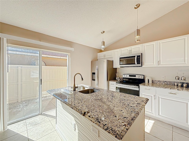 kitchen with sink, stainless steel appliances, pendant lighting, lofted ceiling, and a kitchen island with sink