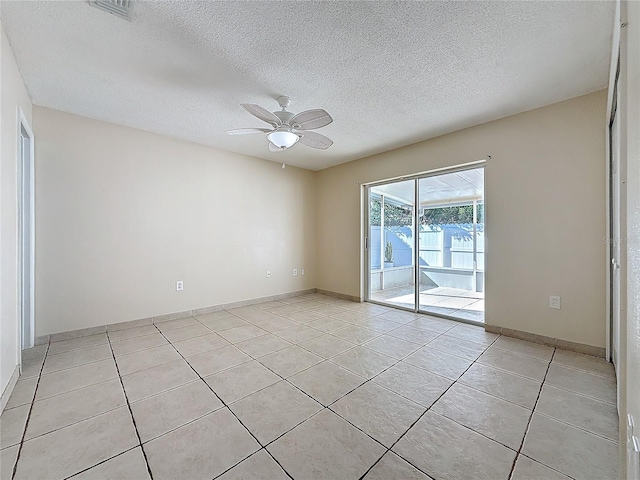 tiled empty room featuring a textured ceiling and ceiling fan