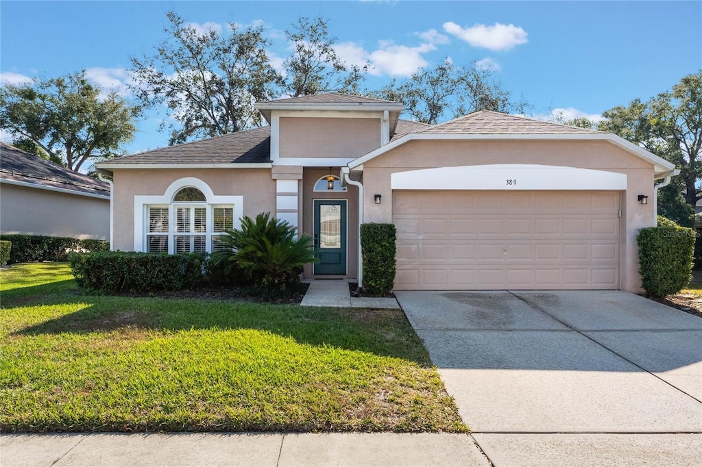 view of front of property featuring a front lawn and a garage