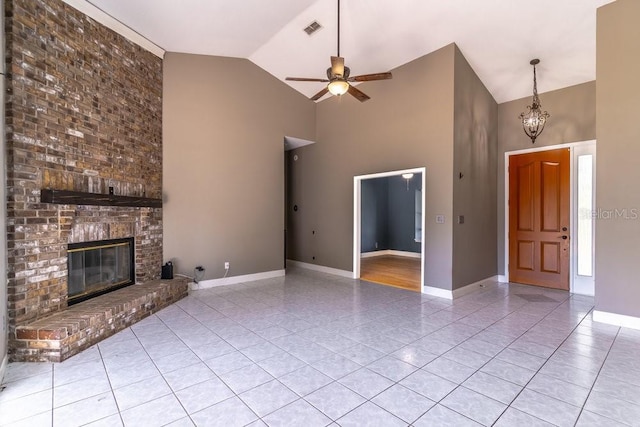 unfurnished living room with ceiling fan with notable chandelier, light tile patterned floors, a fireplace, and high vaulted ceiling