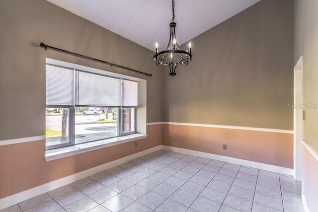 tiled empty room with a chandelier