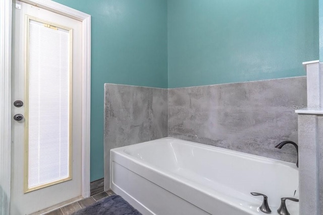 bathroom featuring a washtub and tile patterned flooring