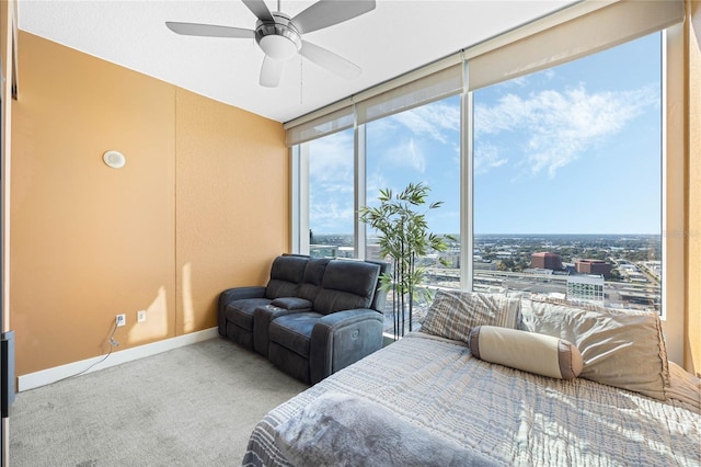 bedroom with multiple windows, ceiling fan, light carpet, and a wall of windows