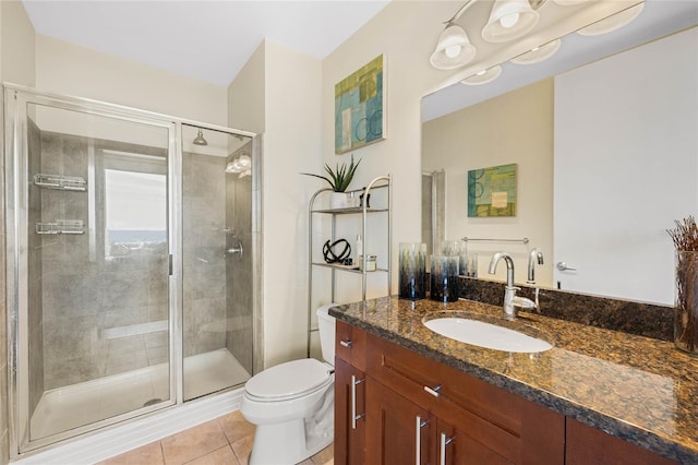 bathroom featuring tile patterned flooring, vanity, toilet, and a shower with shower door