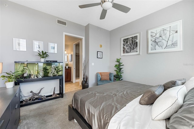 bedroom with connected bathroom, ceiling fan, and light colored carpet