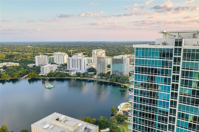 aerial view at dusk featuring a water view