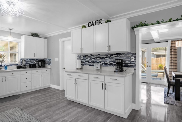 kitchen featuring ornamental molding, sink, pendant lighting, and white cabinets