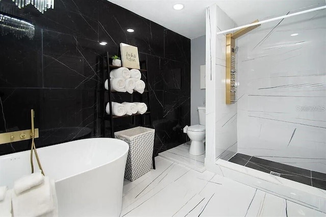 bathroom featuring a tub to relax in, tile walls, and toilet